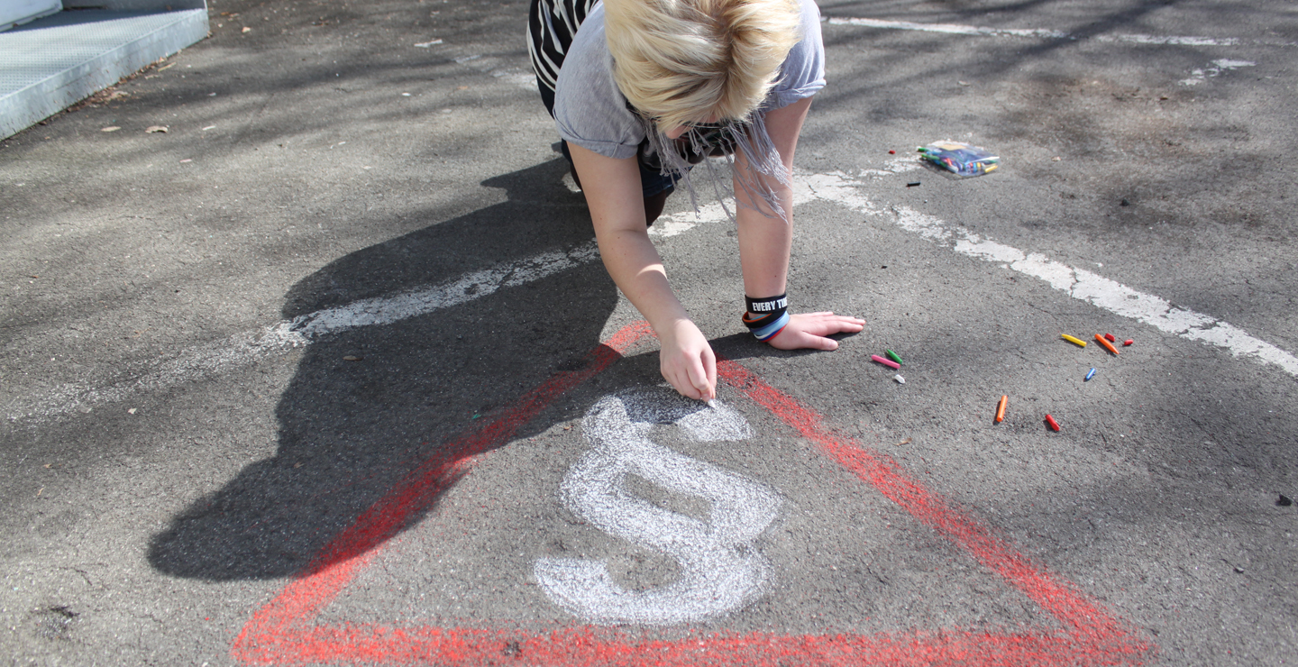 Jugendlichen zeichnet ein Paragraphensymbol auf den Boden