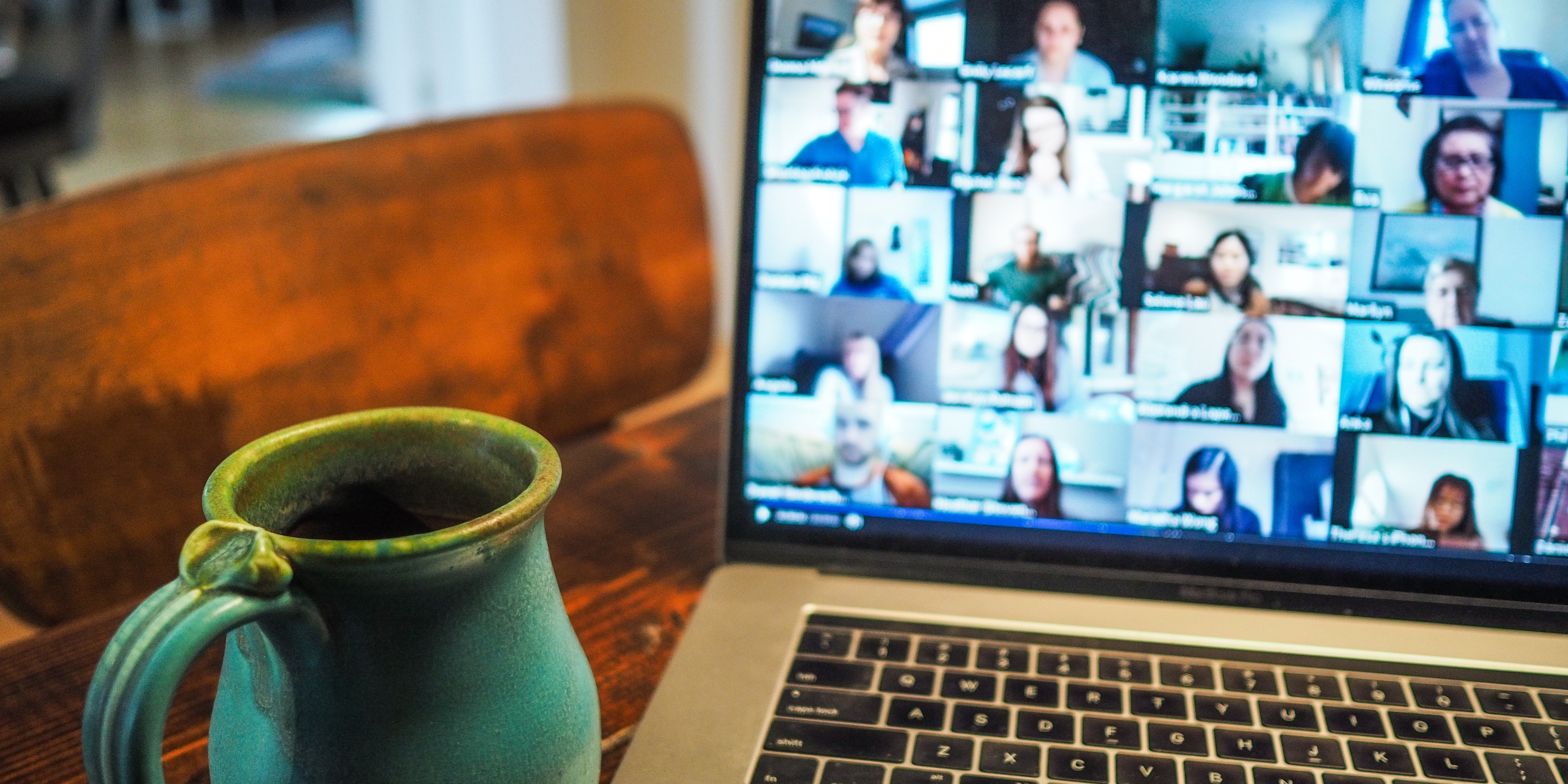 Tasse vor einem Laptop mit einem Online-Meeting am Screen