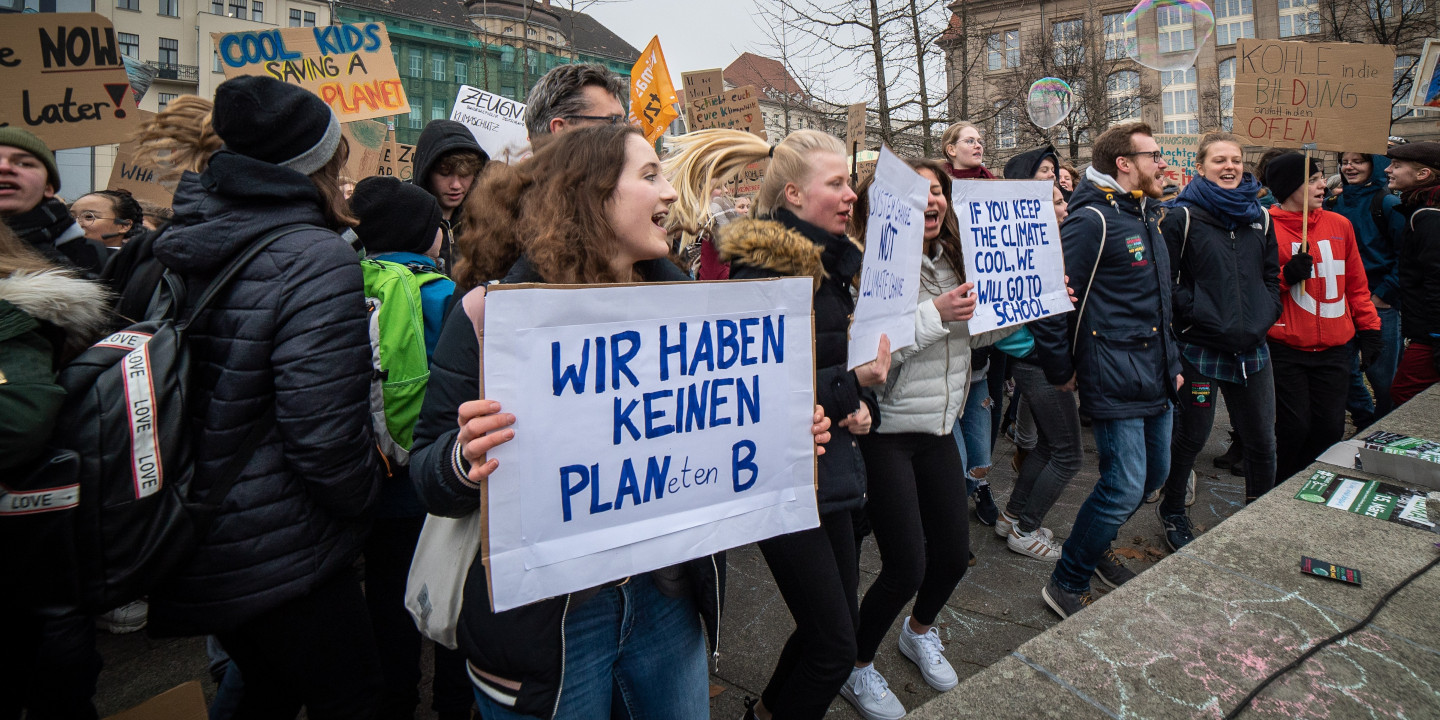 Jugendliche protestieren gegen den Klimawandel und halten Schilder in die Höhe.